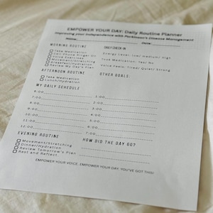 May include: A white daily routine planner titled "EMPOWER YOUR DAY" with sections for morning, afternoon, and evening routines. It includes a daily schedule and a "How Did The Day Go?" section. The planner is designed for Parkinson's Disease Management.