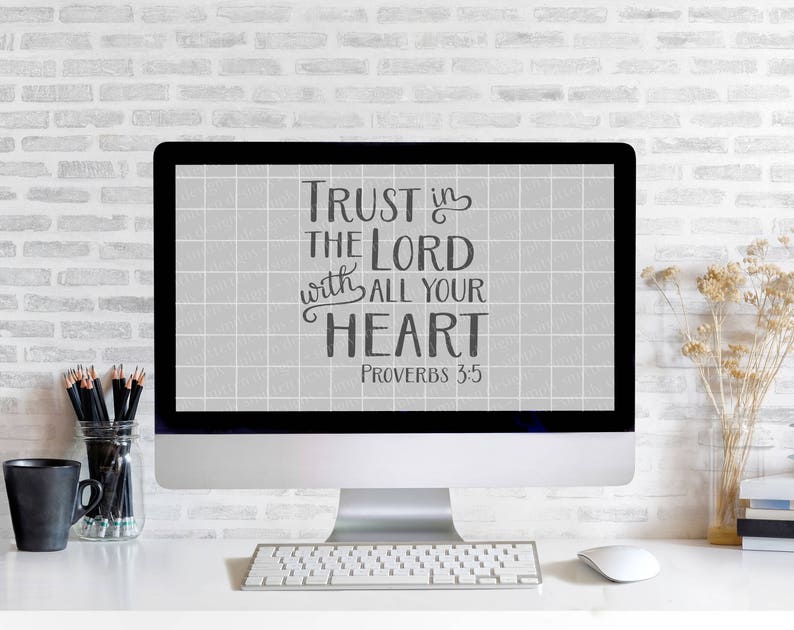 Może przedstawiać: Komputer stacjonarny wyświetla tekst "Trust in the Lord with all your heart Proverbs 3:5" czarną czcionką na szarym tle w kratkę. Na białym biurku znajdują się klawiatura, mysz, oł&oacute;wki i czarny kubek.