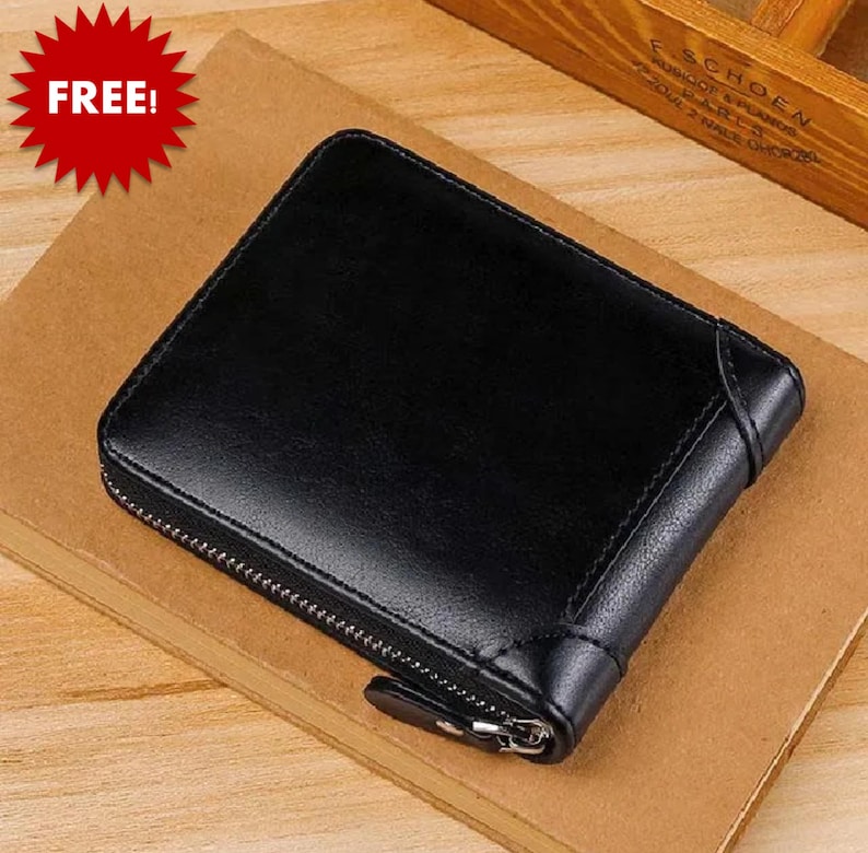 May include: A black leather wallet with a zipper closure. The wallet is rectangular and appears to be made of smooth leather. The word "FREE!" is in a red starburst in the upper left corner.