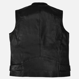 May include: A black leather vest with a stand-up collar. The vest has a tailored fit, with seams and panels creating a structured look. Features include shoulder panels and two small pockets near the waist. The back view shows a curved hemline.