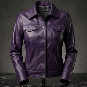 May include: A deep purple leather jacket featuring a classic collar, long sleeves with buttoned cuffs, and a front button-down closure. The garment includes two chest pockets with buttoned flaps and vertical seam detailing along the front panels.
