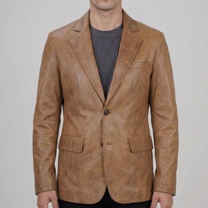 May include: A tan leather blazer with a two-button closure, notched lapels, and two front pockets. The jacket has a classic, tailored fit and a slightly distressed appearance. The blazer is a versatile piece of outerwear.
