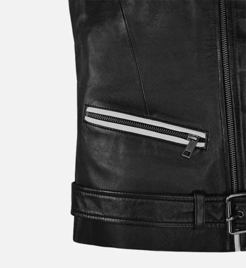 May include: Close-up of a black leather jacket with a silver zipper and a white stripe detail on the pocket. The jacket has a belt with a silver buckle at the waist. The leather appears smooth and the stitching is precise.
