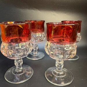 Peut inclure: Ensemble de quatre gobelets vintage en verre rouge rubis et transparent. Les bols sont d'un rouge vif, tandis que les pieds et les bases sont transparents. Les gobelets ont un motif décoratif et texturé sur le bas du bol.