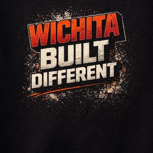 May include: Black t-shirt with the words "WICHITA BUILT DIFFERENT" in a distressed, orange and white design. The text has a 3D effect with a grunge-style splatter background.