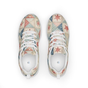 Op de afbeelding: Hardloopschoenen met een patchwork quilt ontwerp. De schoenen hebben een crèmekleurige basis met rode, blauwe en crèmekleurige ster- en bloempatronen. Witte veters en zolen maken het ontwerp compleet.