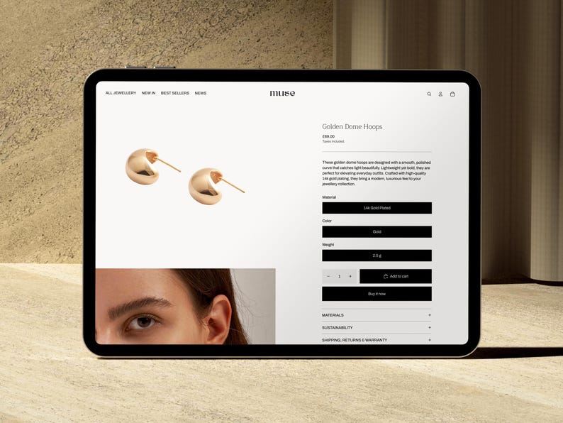 Puede incluir: Una tableta muestra un sitio web de joyer&iacute;a con aros dorados. Los aros son lisos, pulidos y tienen un dise&ntilde;o curvo. El sitio web incluye detalles del producto, como el material, el color y el peso de 0,5 g.