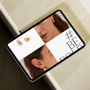 Puede incluir: Una tableta digital muestra pendientes dorados y el texto "#BE BOLD". Los pendientes se muestran en una cuadr&iacute;cula con im&aacute;genes de una persona que los lleva puestos. Los pendientes tienen un dise&ntilde;o liso y redondeado.