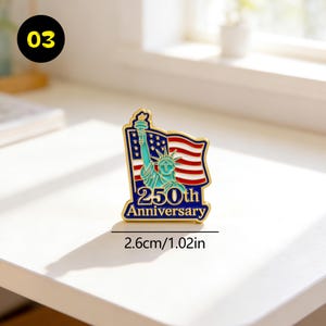 May include: A gold-colored pin featuring the Statue of Liberty and the American flag. The pin commemorates the "250th Anniversary" with a blue border and red, white, and blue colors. The pin measures 1.02 inches in length.
