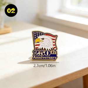 May include: A gold-colored pin featuring an American flag design with a bald eagle and the text "250th Anniversary." The pin measures 1.06 inches in length. The eagle has a white head and a yellow beak.