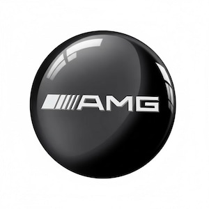 May include: A shiny, black, spherical emblem with the silver AMG logo. The emblem has a reflective surface, with bright highlights. The AMG logo is a stylized text and graphic, often associated with high-performance vehicles.