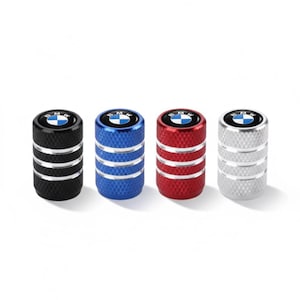 May include: Four metallic tire valve stem caps in black, blue, red, and silver. Each cap features a BMW logo on a black background. The caps have a ridged design and are cylindrical in shape.