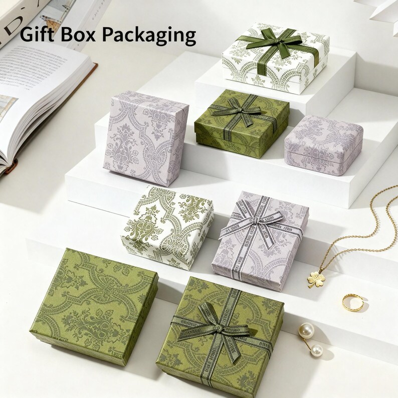 May include: Several decorative gift boxes in various sizes and colors, including green, white, and lavender. The boxes are adorned with patterned designs and ribbons. The text "Gift Box Packaging" is at the top.