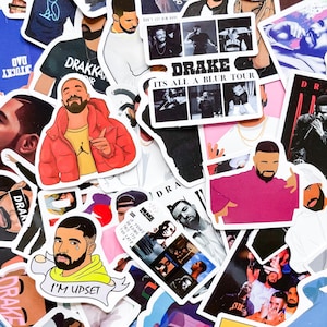 May include: A collection of colorful stickers featuring illustrations of Drake. The stickers showcase various images of the artist, including portraits and graphics. Some stickers have text, including "DRAKKA", "ITS ALL A BLUR TOUR", and "I'M UPSET".
