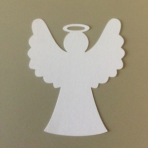 May include: White paper angel cutout with a halo. The angel has wings and a simple body shape.