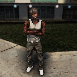 Könnte beinhalten: Eine Person trägt ein weißes Tanktop, Camouflage-Hose und weiße Turnschuhe. Die Person hat Tätowierungen auf den Armen und steht draußen auf einem Bürgersteig.