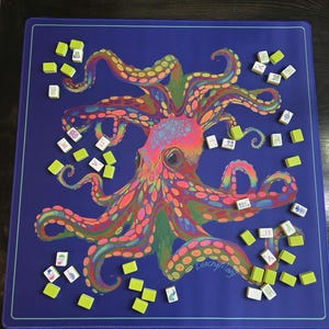 May include: A blue game mat featuring a colorful octopus design with a variety of game tiles scattered around it. The octopus is rendered in shades of pink, orange, green, and yellow. The mat has a light blue border and the text "peachy mary" is visible.