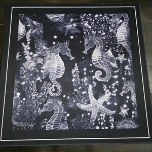 May include: Black and white mousepad featuring a detailed illustration of seahorses, starfish, and aquatic plants. The design includes a variety of seahorses in different poses, surrounded by bubbles and coral. The mousepad has a black border and a white inner border.