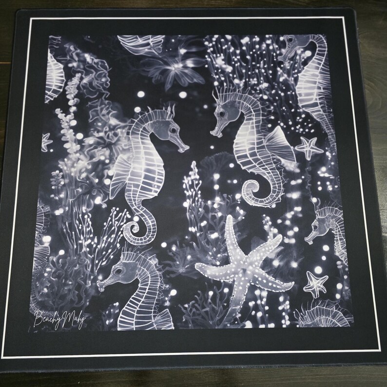 May include: Black and white mousepad featuring a detailed illustration of seahorses, starfish, and aquatic plants. The design includes a variety of seahorses in different poses, surrounded by bubbles and coral. The mousepad has a black border and a white inner border.