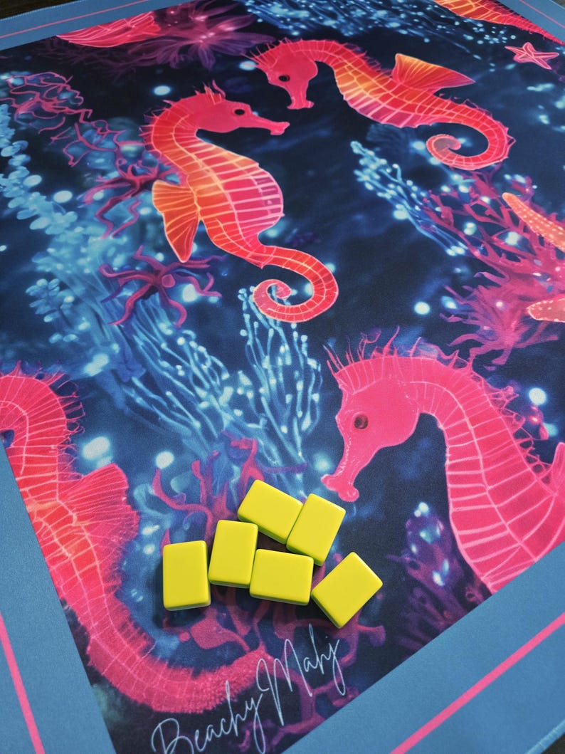 May include: A game board featuring a vibrant underwater scene with pink seahorses and coral against a dark blue background. Six yellow game tiles are scattered on the board. The text "Beachy Mahj" is in the lower left corner.