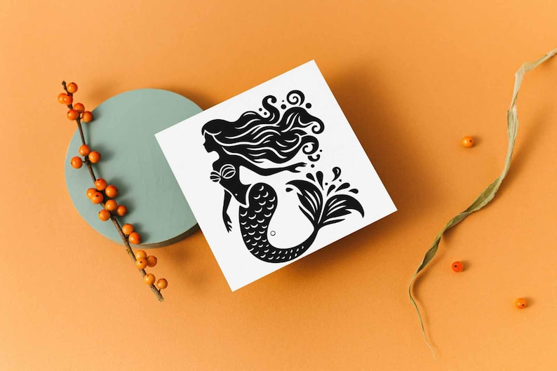 May include: A black and white mermaid illustration on a white square. The mermaid has long flowing hair and a fishtail. The image is set against an orange background with a teal circle and orange berries.