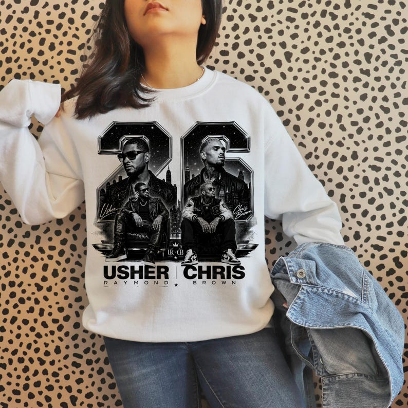 A black and white digital art piece featuring portraits of singers Usher and Chris Brown sitting in front of a stylized city skyline with the text "USHER x CHRIS" and decorative "22" branding elements.