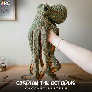 Puede incluir: Un gran pulpo de ganchillo hecho a mano en tonos verdes y naranjas. El pulpo tiene un aspecto texturizado con tentáculos detallados y una cabeza redondeada. El texto "CASPIAN THE OCTOPUS CROCHET PATTERN" se muestra en la parte inferior de la imagen.