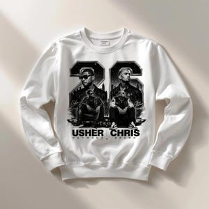 A black and white digital art piece featuring portraits of singers Usher and Chris Brown sitting in front of a stylized city skyline with the text "USHER x CHRIS" and decorative "22" branding elements.