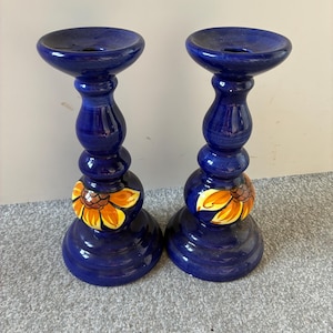 Coppia di candelabri vintage in ceramica da studio con smalto dipinto a mano e motivo floreale di girasoli. Mensole alte per candele da tavola, stile country, con decorazioni floreali.