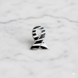 May include: A black and white striped ribbon pin with a silver border. The pin is in the shape of a ribbon, with a curved top and a loop in the middle. The stripes are evenly spaced and run horizontally across the ribbon.