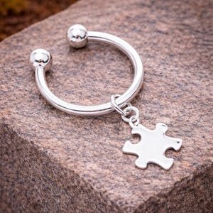 May include: A white ceramic mug with a black handle and the text "But First, Coffee" in a black, bold font. The mug is on a white surface.