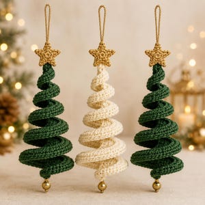 May include: Three hanging ornaments shaped like spiral Christmas trees. Two are dark green and one is cream-colored. Each features a gold crocheted star at the top, a gold hanging loop, and a small gold bead at the bottom point of the spiral.