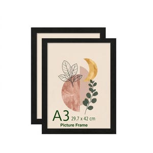 May include: Two black A3 picture frames. Each frame features a beige background with an abstract design of a pink circle, a gold crescent moon, and green leaves. The text "A3 29.7 x 42 cm Picture Frame" is visible.