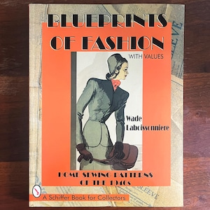 May include: A vintage book titled "BLUEPRINTS OF FASHION" with an illustration of a woman in a 1940s outfit. The cover is orange and beige, with the text "HOME SEWING PATTERNS OF THE 1940s" and "A Schiffer Book for Collectors".