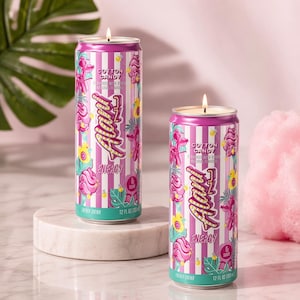 K&ouml;nnte beinhalten: Zwei nach Zuckerwatte duftende Kerzen in Form von Energy-Drink-Dosen. Die Dosen sind rosa und wei&szlig; gestreift mit floralen und textlichen Designs. Jede Kerze hat einen brennenden Docht und ist 355 ml gro&szlig;.
