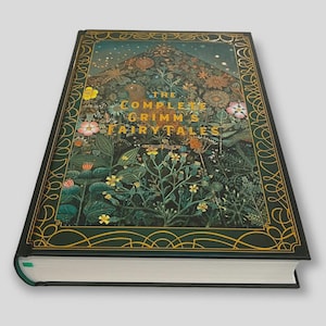 May include: A hardcover book titled "The Complete Grimm's Fairy Tales." The cover features a detailed illustration of a forest scene with flowers, plants, and a bird, framed by a gold border on a dark green background.