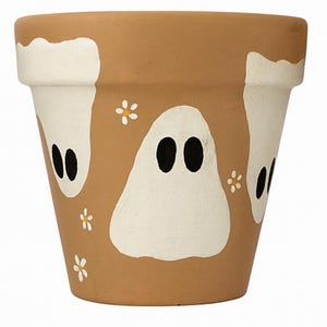 May include: A terracotta-colored flower pot decorated with white ghost figures and small white flower accents. The ghosts have black oval eyes. The pot is a classic shape, suitable for indoor or outdoor use.