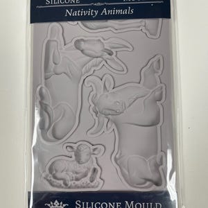 May include: A light gray silicone mould for crafting, featuring recessed shapes of nativity animals including a donkey, a goat, and a lamb. The packaging is labeled with the text Silicone Mould Nativity Animals and Decoupage Queen.