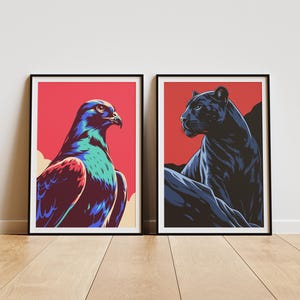 Peut inclure: Deux affiches encadrées. La première présente une illustration colorée d'un oiseau de proie sur fond rouge. La seconde affiche représente une panthère noire sur fond rouge. Les deux sont dans des cadres noirs.