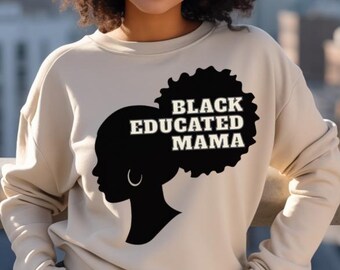Könnte beinhalten: Beiges Sweatshirt mit dem Text "BLACK EDUCATED MAMA" in schwarzer Schrift. Die Grafik zeigt eine Silhouette eines Frauenprofils mit Afro und Ohrring. Im Hintergrund ist eine Stadtkulisse zu sehen.
