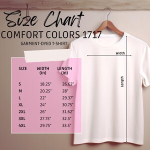 Puede incluir: Una camiseta blanca Comfort Colors 1717 te&ntilde;ida en prenda colgada de una percha de madera. Una tabla de tallas muestra medidas en pulgadas para las tallas S a 4XL, incluyendo ancho y largo.