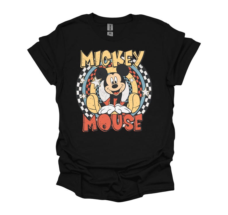 May include: Black t-shirt featuring a retro design of Mickey Mouse. The graphic includes the words "Mickey Mouse" in yellow and red, with Mickey in the center, surrounded by a rainbow and stars.