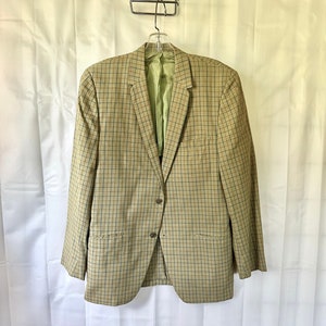 May include: A tan blazer with a brown and black plaid pattern. The blazer has a single button closure and two front pockets.