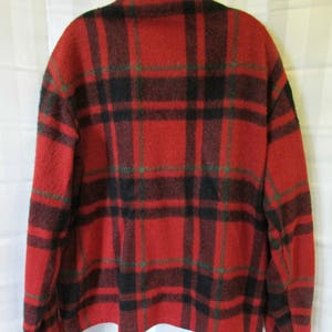 May include: Red, black, and green plaid flannel shirt with long sleeves and a button-up front.