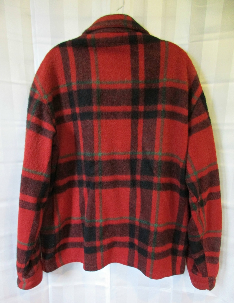 May include: Red, black, and green plaid flannel shirt with long sleeves and a button-up front.