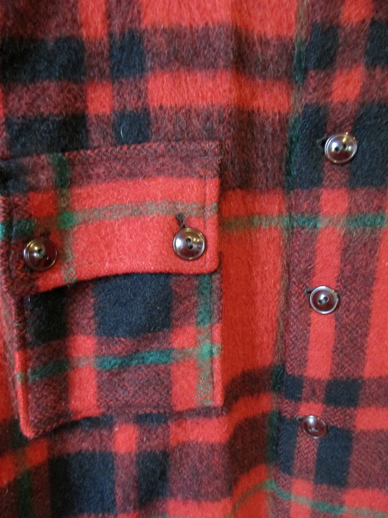 May include: Red, black, and green plaid flannel shirt with a patch pocket and dark brown buttons.