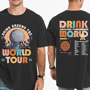 May include: Black t-shirt with a colorful graphic design. The front features the text "DRINK AROUND THE WORLD TOUR 2026" with a stylized image of a geodesic sphere. The back has "DRINK AROUND THE WORLD" and a list of countries.