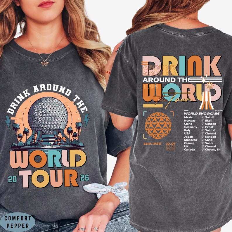 May include: Dark gray t-shirt with a colorful "Drink Around The World Tour" graphic. The front features a globe design and the text "20 TOUR 26". The back has a list of countries and the text "Drink Around The World".
