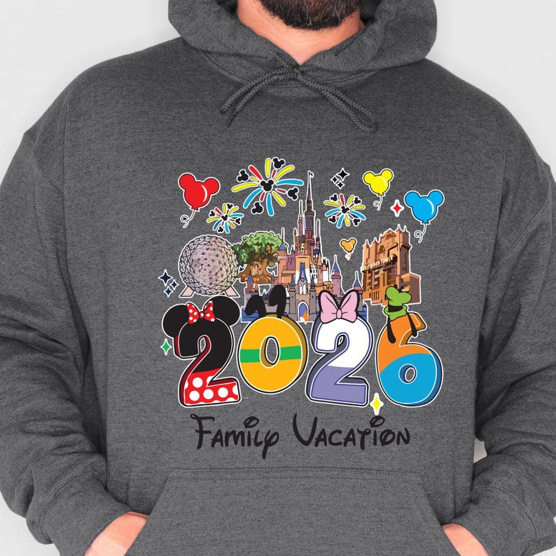 May include: Dark gray hoodie with a colorful graphic design. The design features the numbers "2026" with Mickey and Minnie Mouse ears, a castle, and the words "Family Vacation". Balloons and fireworks are also included in the design.