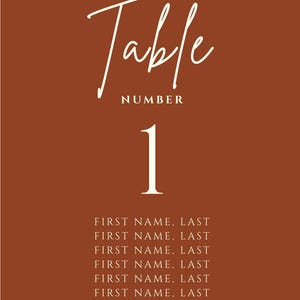 May include: A terracotta-colored table number card with white script text that reads "Table" and "NUMBER". The number "1" is centered below, with guest names listed at the bottom. Ideal for weddings and events.